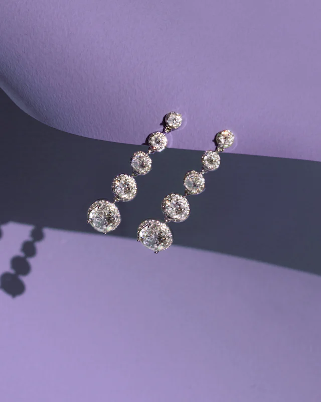 Diamond drop earrings on a purple background