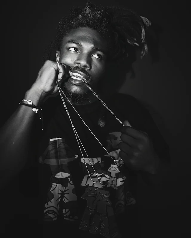 Man holding a silver chain in his teeth